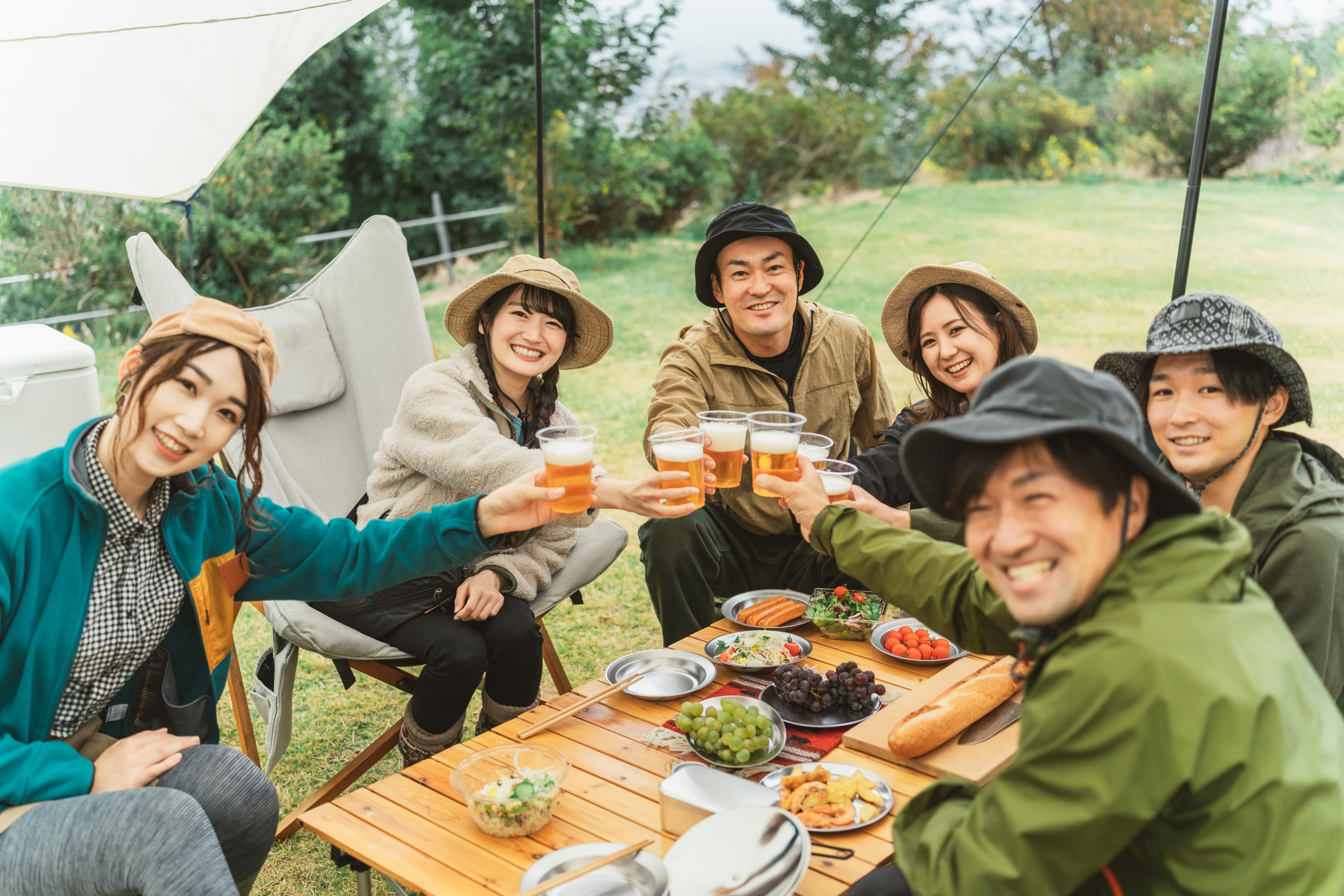 バーベキューで乾杯をする男女六人